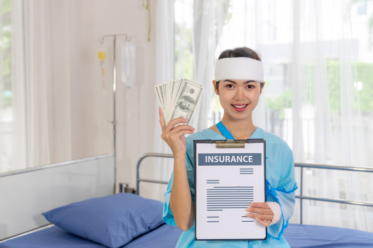 a woman with a bandaged head holds insurance and money in her hands