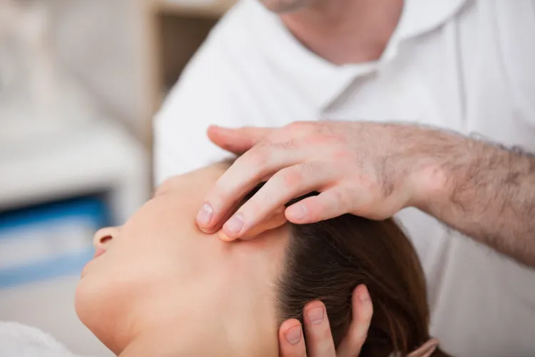 a chiropractor massages a patient's head