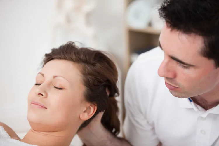 a chiropractor massages a patient's head